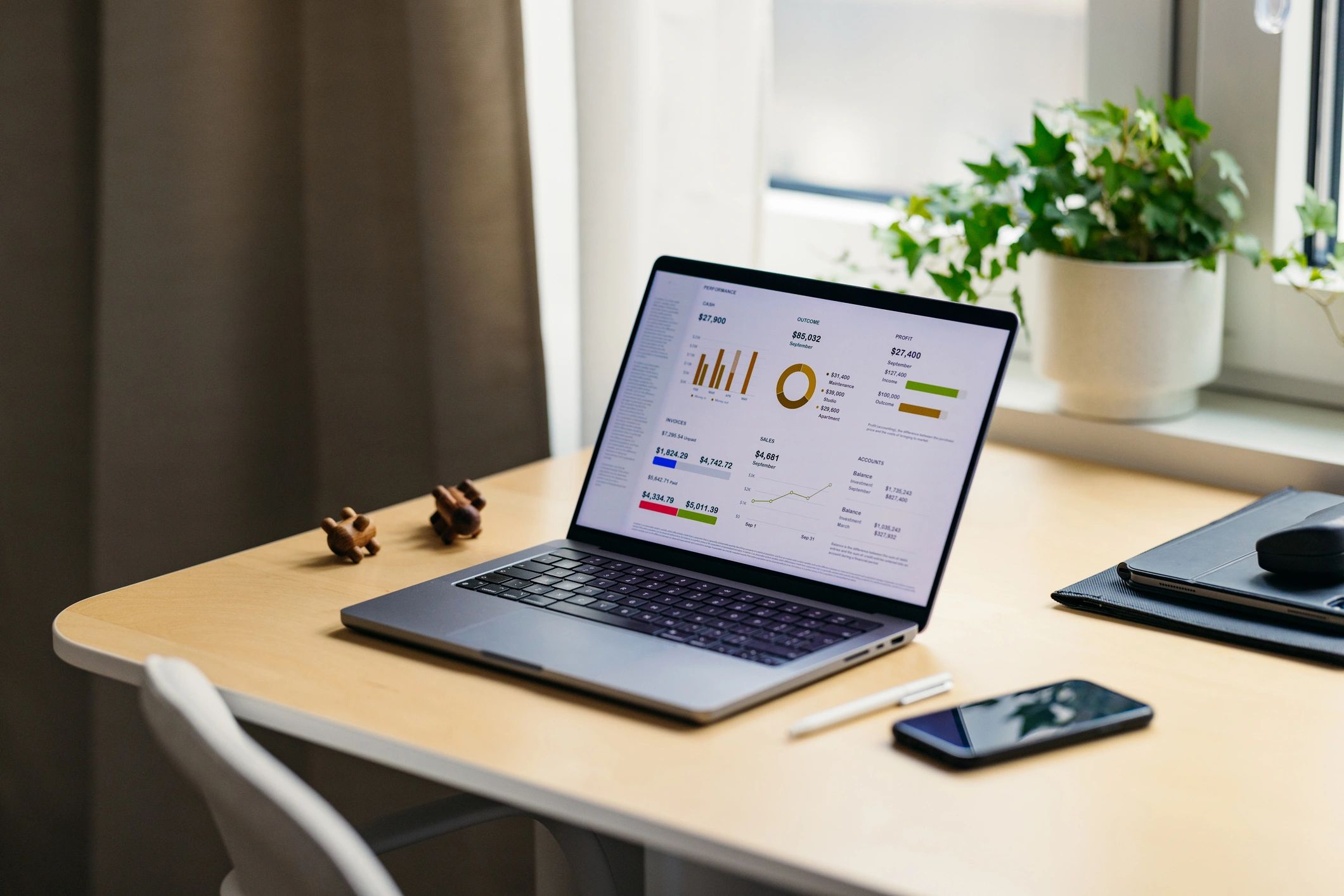 Laptop and mobile phone showing business analytics on a desk