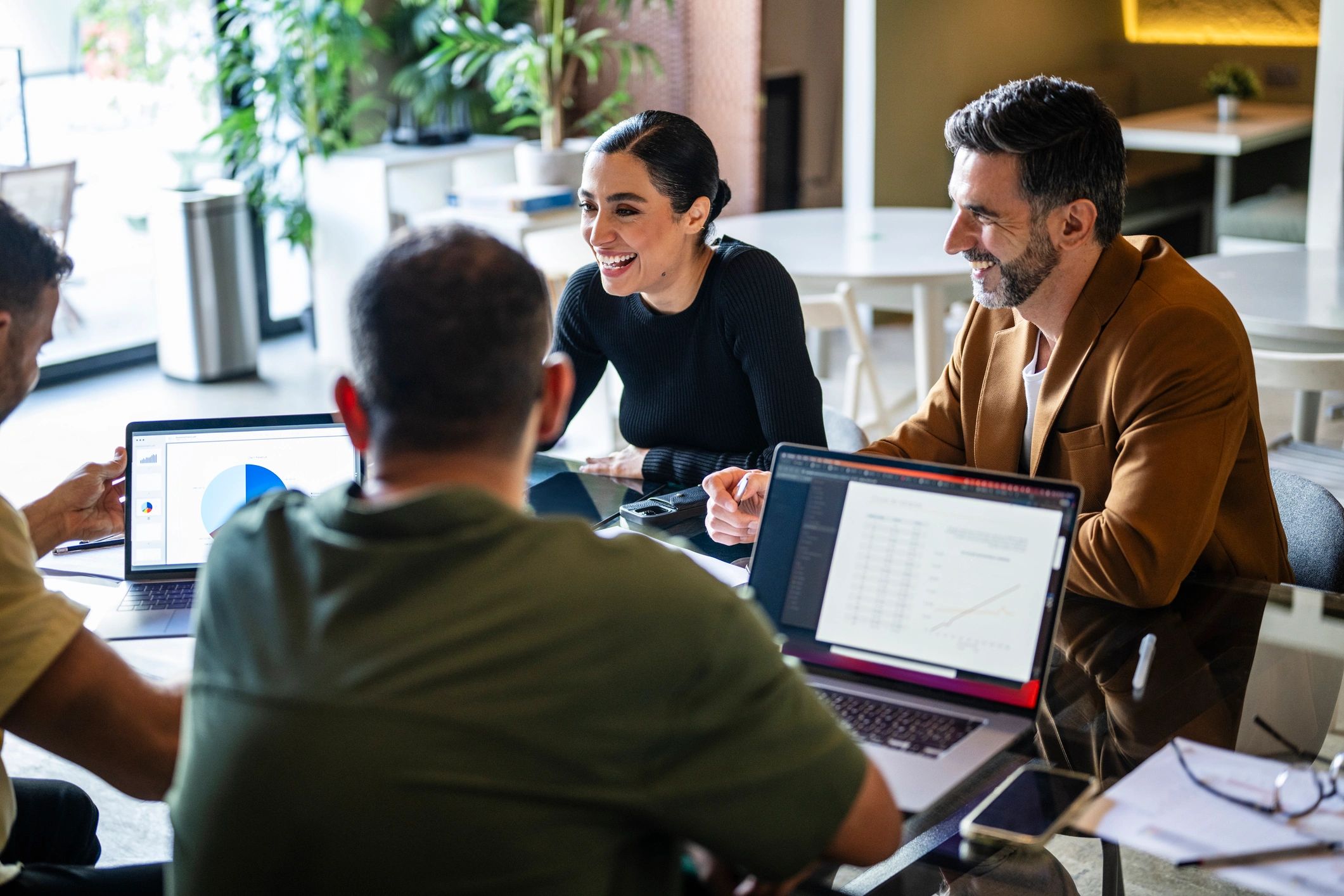 E-commerce team collaborating around laptops in a meeting